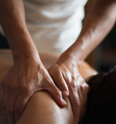 Masseuse massaging client's shoulder