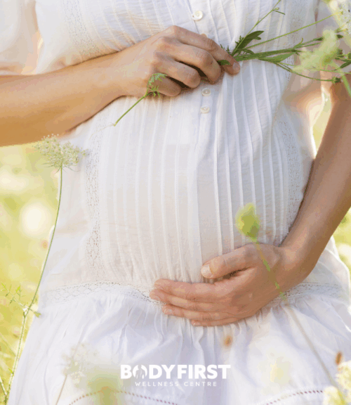 natural approach to fertility | Body First Wellness Center pregnant lady in flower garden